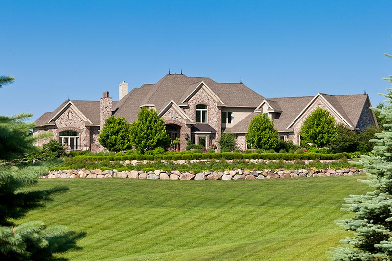 Large mansion home with beautifully landscaped yard.