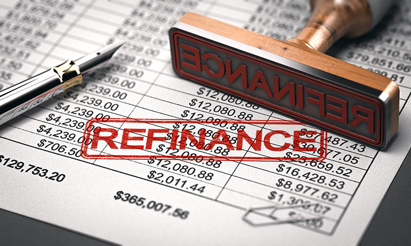 Close up of a financial spread sheet with the word "refinance" rubber stamped in red.